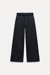 Pantalón de jean azul oscuro, corte wide leg, tiro alto, con cinturón de la misma tela y hebilla metálica.