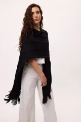 Ruana negra con flecos de algodón.