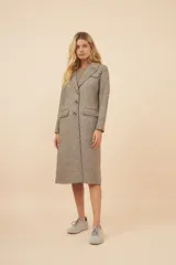 Tapado largo color beige con cuello solapa y corte recto. Cierre frontal con botones, detalles aplicados en la parte delantera, tajo en la espalda y bolsillos ojal con tapa. Con forro. Hecho en Uruguay con tela 100% lana fina sin teñir.