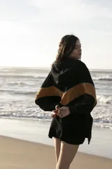 Hoodie negro con capucha y mangas largas, con una franja horizontal color marrón a la altura del pecho y la espalda.