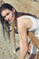 Musculosa blanca de punto acanalado, corte entallado, con escote redondo tanto en la parte delantera como en la trasera.