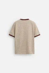 Camiseta de manga corta con cuello redondo y corte regular. Diseño a rayas horizontales en color crema y marrón, con ribete marrón en cuello y mangas.