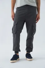 Pantalón cargo gris oscuro, corte slim, con cierre de botón y cremallera, trabillas para cinturón, bolsillos cargo con botón y puños ajustados.