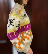 Sweater de lana merino con cuello redondo y diseño con motivos geométricos en tonos azul, marrón, naranja, verde y beige.