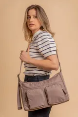 Bandolera de tafeta impermeable, liviana, con dos compartimientos principales, dos bolsillos con cierre y correa regulable con hebilla.