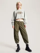 Buzo Tommy Jeans de corte cropped, color gris claro, con logo bordado en el frente.