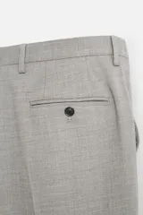 Pantalón de vestir gris claro con textura, corte regular fit, bolsillos laterales y traseros de doble vivo con botón. Cierre frontal con cremallera y botón.