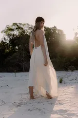 Vestido largo de color blanco, con escote en V pronunciado y tiras largas que permiten anudarlo de múltiples formas. Presenta tajo en ambos laterales y forro interno.