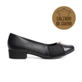 Zapato de cuero negro con punta redonda, tacón bajo y ancho. Presenta paneles laterales de tela elástica y un adorno metálico dorado en la parte superior.