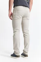 Pantalón de jean color beige, corte recto, tiro medio y con presillas para cinturón.
