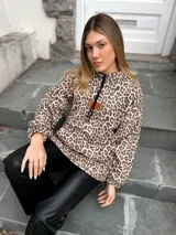 Canguro con estampado animal print de leopardo, forrado en peluche suave, con capucha ajustable, frunces en las mangas y tajos laterales.