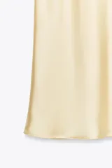 Falda midi color crema de satén, de tiro alto y corte recto.