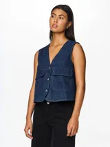 Chaleco denim azul oscuro, con cuello en V, cierre frontal con botones y bolsillos de parche.