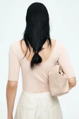 Top color rosa pálido, entallado, de punto elástico, con escote bailarina, espalda en U y mangas cortas.