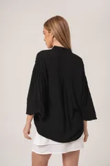 Camisa blanca de manga larga con detalle de bolitas en la tela.