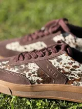 Zapatillas bajas color verde militar de gamuza con suela marrón y detalle trasero en color crema.