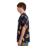Camisa de manga corta azul con estampado de soles amarillos y naranjas.