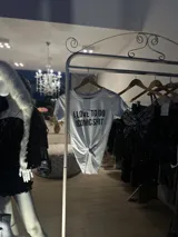 Remera blanca de algodón con estampado de texto en espejo.