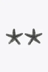 Par de aros metálicos con forma de estrella de mar con textura en relieve. Cierre con tuerca.