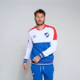 Buzo deportivo Umbro del Club Nacional de Football. Diseño con bloques de color blanco, azul y rojo. Incluye logo de Umbro y escudo del club en el pecho.