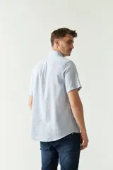 Camisa de manga corta color beige claro, confeccionada en lino y algodón, con cuello abotonado, bolsillo en el pecho y logo bordado. Corte semi slim.