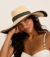 Sombrero de playa de paja color beige con cinta negra y ala ancha con pespuntes.