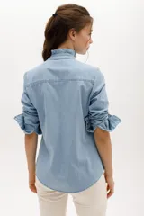 Camisa celeste de manga larga con cuello mao y volados en el frente.