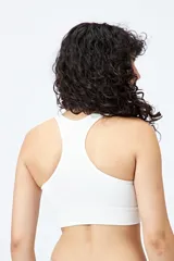 Top deportivo blanco de diseño seamless con escote en V y breteles anchos.