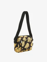 Bolso bandolera negro con estampado de bananas amarillas. Tiene un compartimento principal con cierre de cremallera y correa ajustable para llevar al hombro o cruzado.
