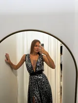 Vestido largo de seda con estampado animal print tornasolado en tonos azul y plateado. Presenta escote pronunciado en V, tirantes anchos y un cinturón ancho de eco cuero negro que marca la cintura. La falda es amplia y tiene una abertura lateral alta.