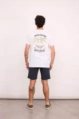 Remera blanca de manga corta con cuello redondo y estampado en la espalda con palmeras, ángel en una hamaca y las palabras 'Paradise Holiday' y 'Brixton'.