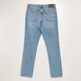 Jean recto de corte clásico, de color azul claro con acabado desgastado y cinco bolsillos.