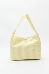 Bolso tote de algodón a rayas amarillas y blancas con asas de hombro.