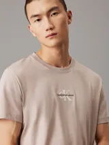 Remera color beige claro de corte recto, cuello redondo y mangas cortas. Estampado frontal con el logo de Calvin Klein Jeans en color blanco.