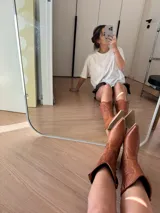 Bota texana de cuero color marrón, con caña media, punta fina y taco de madera.