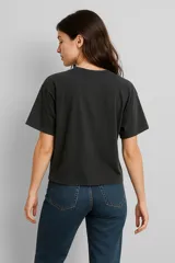 Remera blanca de corte holgado con estampado de flores negras.
