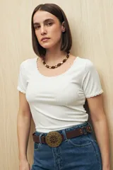Remera color ladrillo de manga corta y cuello redondo con puntillas en mangas y escote.