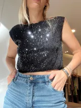 Blusa crop top negra con lentejuelas y hombreras.