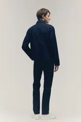 Pantalón de corte slim fit color negro, confeccionado en sarga de algodón, con cinco bolsillos, cierre con cremallera y botón.