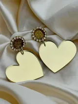 Par de aros colgantes dorados con forma de corazón y base circular con strass.