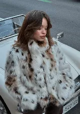 Campera corta de piel sintética con estampado animal print en tonos blanco, marrón y negro.