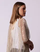Kimono plisado dorado con lurex, ruedo con flecos y diseño abierto.