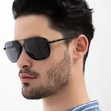 Lentes de sol INVU modelo B1008A, con montura metálica negra y lentes polarizadas grises.