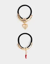 Set de dos gomitas de pelo elásticas negras con apliques metálicos dorados y dijes colgantes: una con dije de corazón y otra con dije de pimiento rojo.