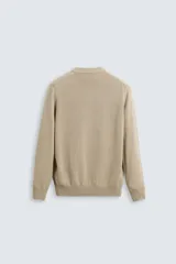 Jersey de punto color beige, con cuello en V y mangas largas.