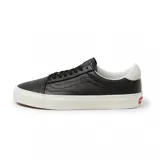 Championes Vans Old Lux negros de cuero con suela blanca.