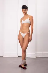 Conjunto de lencería blanco, compuesto por un corpiño tipo bralette de triángulo con tirantes finos ajustables y una bombacha tipo colaless con tiras laterales finas ajustables.