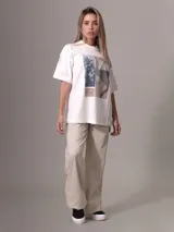 Remera blanca de algodón con corte relaxed, cuello redondo y mangas cortas. Estampado frontal con diseño de collage floral y logo de Calvin Klein Jeans.
