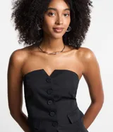 Blusa sin breteles estilo chaleco, color negro con estampado a rayas verticales, botones delanteros, bolsillo falso con solapa y lastex en la espalda.