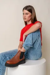 Borcegos negros de cuero vacuno con elástico lateral, suela track y tirador trasero.